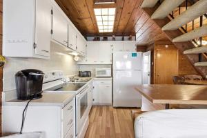 a kitchen with white cabinets and a white refrigerator at Chalet #29 in Stevensville