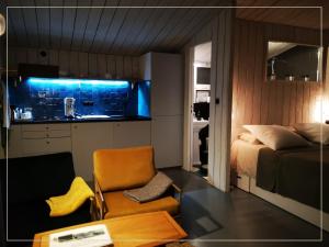a bedroom with a bed and a chair and a table at La Pause En Soi - Cabanes climatisées avec Jaccuzi privatif en option in Ponlat-Taillebourg