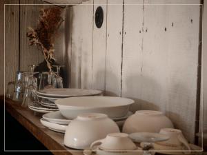 a counter with white bowls and plates on it at La Pause En Soi - Cabanes climatisées avec Jaccuzi privatif en option in Ponlat-Taillebourg +43 photos