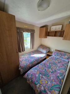 ein kleines Schlafzimmer mit zwei Betten und einem Fenster in der Unterkunft Number34 in Drummore