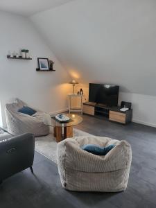 a living room with two couches and a flat screen tv at Ferienwohnung Schöne Aussicht in Hinte