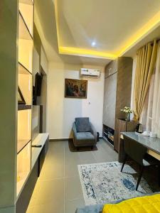 a living room with a couch and a chair and a desk at Luxury Studio Apartment in Ilado