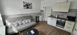 a living room with a couch and a kitchen at Gästehof Bützfleth in Stade