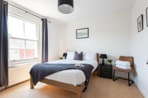 a bedroom with a bed and a window at Talbot Cottage in Lymington