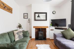 a living room with a couch and a fireplace at Talbot Cottage in Lymington