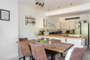 a kitchen with a wooden table and chairs at Talbot Cottage in Lymington