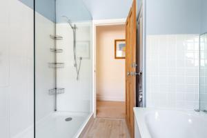 a bathroom with a shower and a white tub at Talbot Cottage in Lymington +25 photos