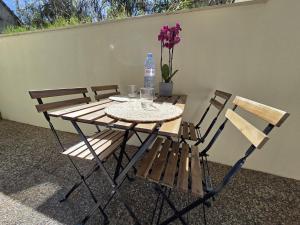 a table with a bottle of water and two chairs at Appartement Dora in Villiers-sur-Marne