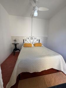 a bedroom with a bed with yellow pillows on it at Hostel El viajero in Tramandaí