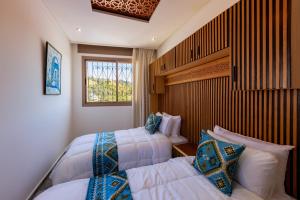 a bedroom with two beds and a window at Riad Seddiki in Chefchaouen +124 photos