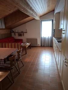 a living room with a table and a kitchen at Campiglio Trilocale Monte Spinale in Madonna di Campiglio