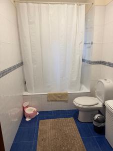 a bathroom with a toilet and a shower curtain at Casa da Lagoa in Geres