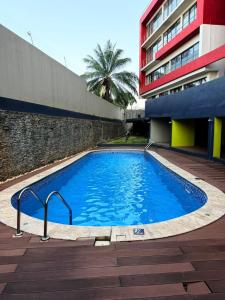 a large blue swimming pool next to a building at Premier Place, Sky Suites in Accra