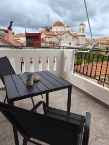 a black table and a chair on a balcony at Lounetta Apartments 2 in Missolonghi