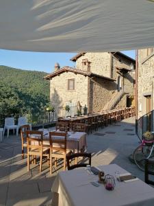 eine Terrasse mit Tischen und Stühlen und ein Gebäude in der Unterkunft Sonic Alchemy Studio BnB in Castel Focognano
