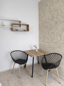 a wooden table and two chairs in a room at Lounetta Apartments 2 in Missolonghi