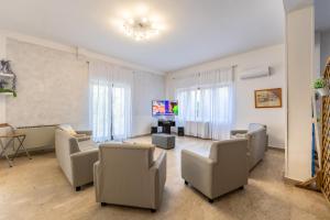 a living room with chairs and a couch and a tv at Hotel Ulisse in Palinuro