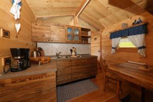a kitchen in a log cabin with a sink and a table at Chalet El Baitel in Bellamonte