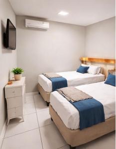 a hotel room with two beds and a television at Hotel Interlagos Plaza in São Paulo
