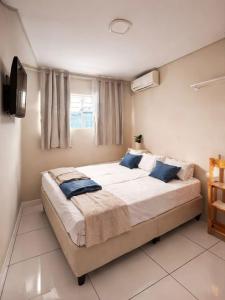 a bedroom with a large bed with blue pillows at Hotel Interlagos Plaza in São Paulo
