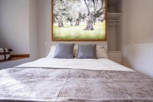 a bedroom with a large bed with a painting on the wall at REFUGIO De PERNACIO in Ávila