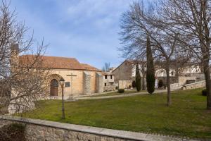 a stone building with a grass yard in front of it at REFUGIO De PERNACIO in Ávila