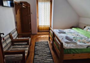 a small bedroom with a bed and a window at La Răscruce in Gărâna