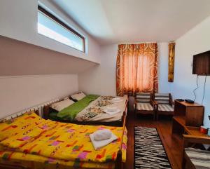 a bedroom with two twin beds and a window at La Răscruce in Gărâna