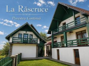a house with a green and white facade at La Răscruce in Gărâna