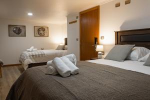 a hotel room with two beds with towels on them at Hotel Los Ríos in Panguipulli +26 photos