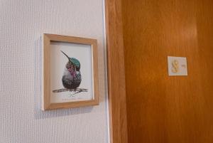 a picture of a bird on a wall next to a door at Hotel Los Ríos in Panguipulli