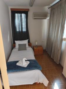 a bedroom with a bed with a towel on it at Aianteio Square Resort -SPA in Aiándion