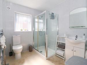 a bathroom with a shower and a toilet and a sink at Southview Bungalow in Barmston +22 photos