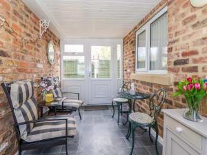a room with chairs and tables and a brick wall at Southview Bungalow in Barmston