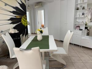 a dining room with a white table and white chairs at Vila Siana in Mamaia