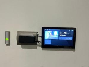 a television attached to a wall with a paper towel dispenser at Residencia Privé in Ica