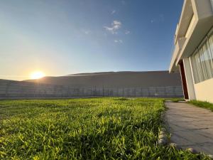 a house with a grassy yard next to a fence at Residencia Privé in Ica +2 photos