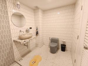 a white tiled bathroom with a sink and a toilet at Retrovibes Sathorn BTS Saphan Taksin ICONSIAM Asiatique Chao Phraya Max 9 persons in Bangkok