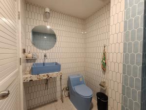a bathroom with a blue toilet and a sink at Retrovibes Sathorn BTS Saphan Taksin ICONSIAM Asiatique Chao Phraya Max 9 persons in Bangkok