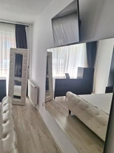 a living room with a couch and a mirror at Vila Siana in Mamaia