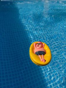 a man on a raft in a swimming pool at Bellissimo Garden Villa in Tsaghkadzor