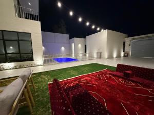 a large room with a red carpet and a basketball court at فلل وشاليهات لفونيا in Buraydah