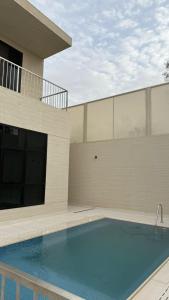 a swimming pool in front of a house at فلل وشاليهات لفونيا in Buraydah +4 photos