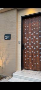 a door to a building with a sign on it at فلل وشاليهات لفونيا in Buraydah