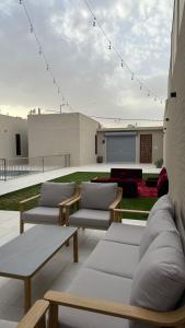 a patio with couches and tables on a building at فلل وشاليهات لفونيا in Buraydah