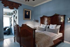 ein Schlafzimmer mit einem großen Bett mit blauen Wänden in der Unterkunft Boutique Hotel Haus Noge Sylt - Kapitaenshaus strandnah in Westerland