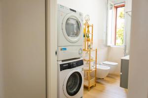 a washer and dryer in a bathroom at Moderno Bilocale Con Parcheggio Privato in Piacenza