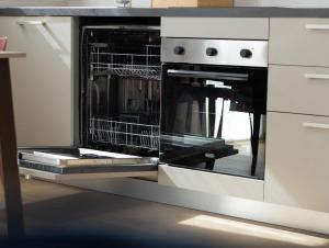 a kitchen with an oven with dishes in it at Moderno Bilocale Con Parcheggio Privato in Piacenza