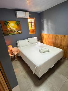 a bedroom with a large white bed in a room at Hospedaria Camarão da ilha in Fernando de Noronha