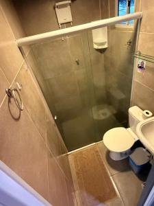 a bathroom with a toilet and a glass shower at Hospedaria Camarão da ilha in Fernando de Noronha